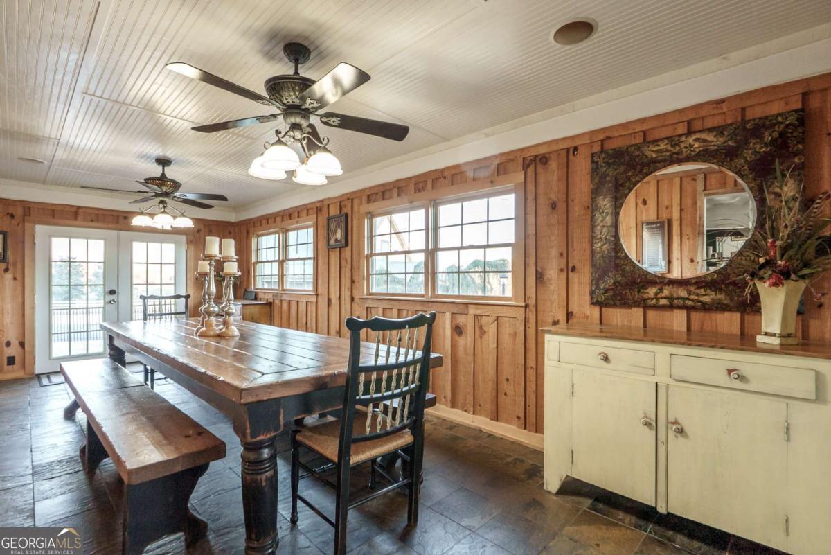 7527 Highway 326 Commerce, GA 30530 - Photo 54 of 100 a dining room with wooden floor a chandelier fan a wooden table and chairs