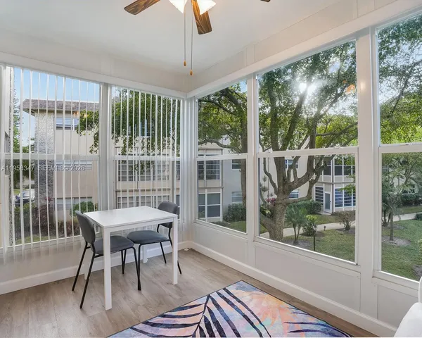 a dining room with furniture a chandelier and wooden floor