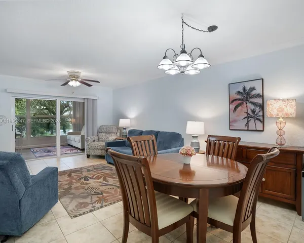 a view of a dining room with furniture a chandelier and a large window