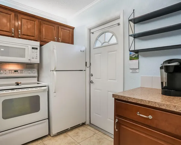 a white refrigerator freezer and a stove sitting inside of a kitchen