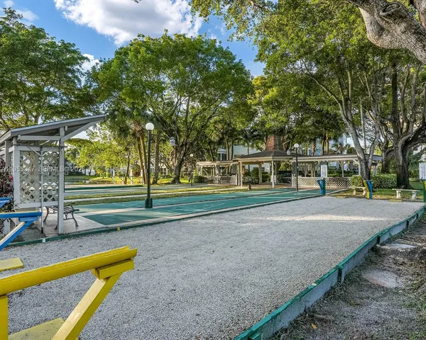 a view of a patio with table and chairs potted plants and a large tree