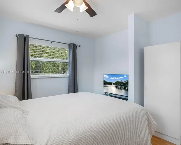 a bedroom with a bed and a large window