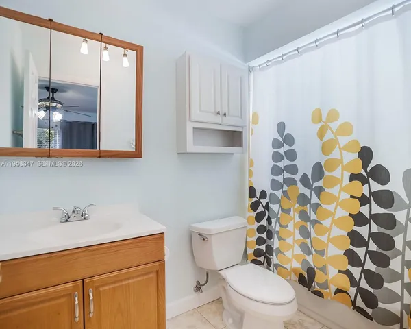 a bathroom with a sink a toilet and shower curtain