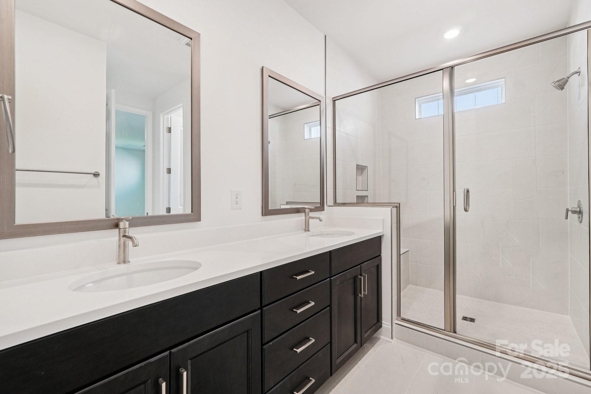 620 Mercury Drive Tega Cay, SC 29708 - Photo 12 of 16 a bathroom with a double vanity sink a large mirror and shower