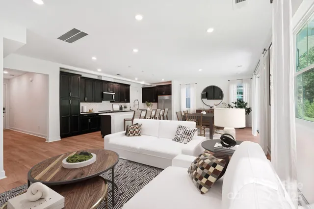 a living room with furniture and a view of kitchen