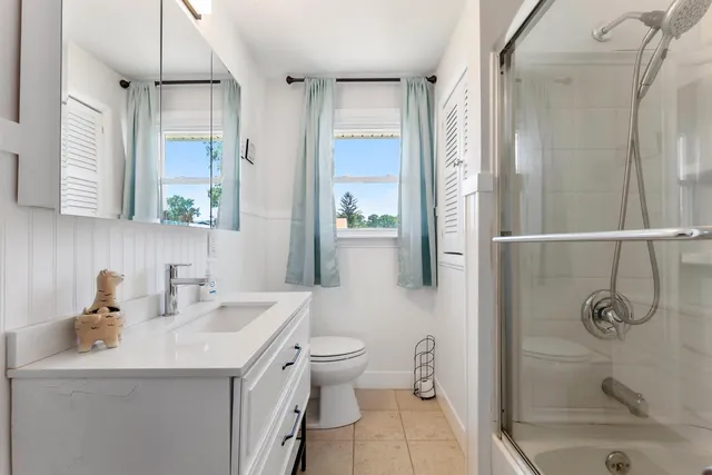 a bathroom with a sink a toilet and shower