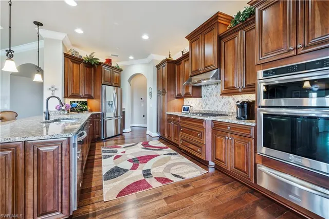 a kitchen with stainless steel appliances granite countertop a stove a sink and a refrigerator