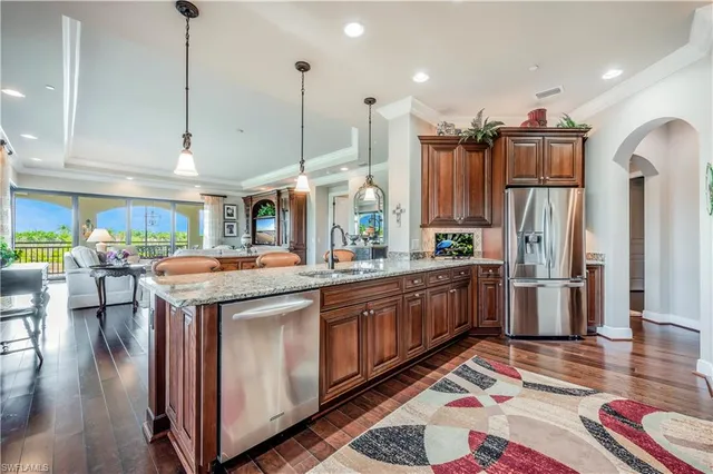 a kitchen with stainless steel appliances granite countertop a sink and a refrigerator