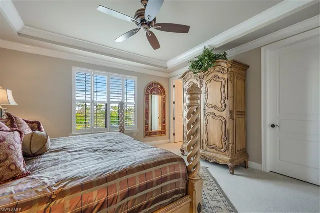 a bedroom with a bed a ceiling fan and a window