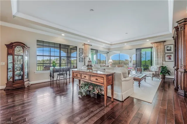a living room with furniture a wooden floor and a large window