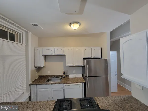 a kitchen with stainless steel appliances granite countertop a refrigerator a stove a sink and a refrigerator