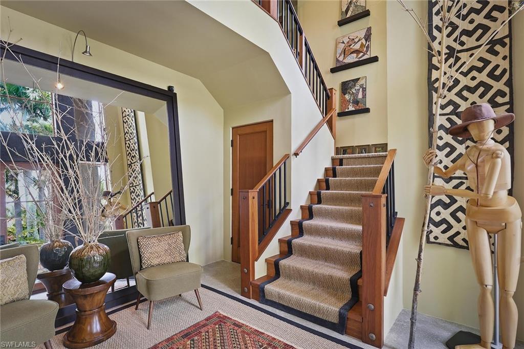 290 Channel Drive Naples, FL 34108 - Photo 16 of 45 a view of staircase with lots of frames on wall and a potted plant