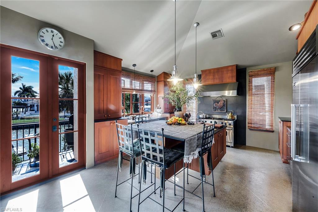 290 Channel Drive Naples, FL 34108 - Photo 23 of 49 a kitchen with stainless steel appliances a dining table chairs and a refrigerator