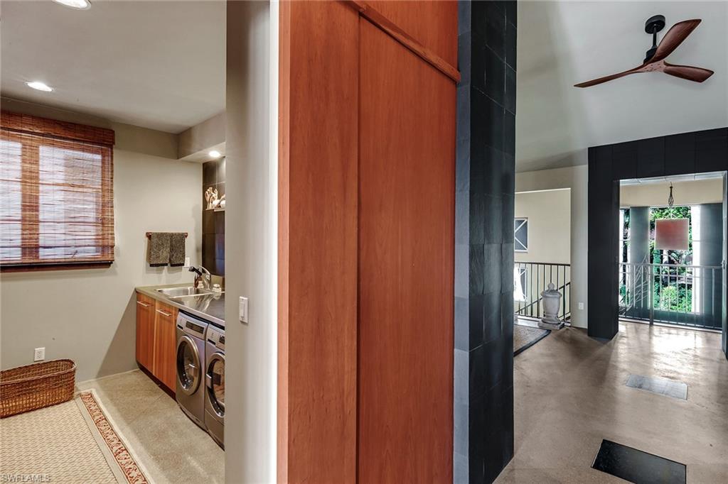 290 Channel Drive Naples, FL 34108 - Photo 28 of 49 a view of a hallway to a livingroom with wooden floor a fireplace and windows