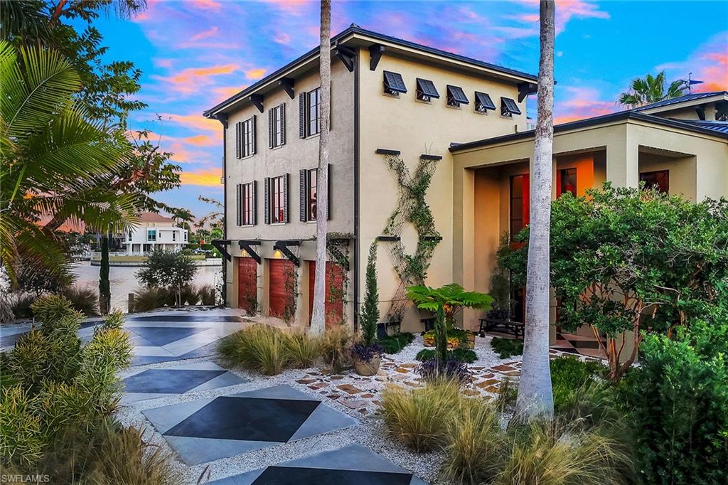 290 Channel Drive Naples, FL 34108 - Photo 3 of 49 a front view of a house with garden