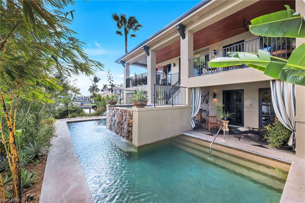 290 Channel Drive Naples, FL 34108 - Photo 38 of 49 a view of a chairs and table in the patio and a fountain