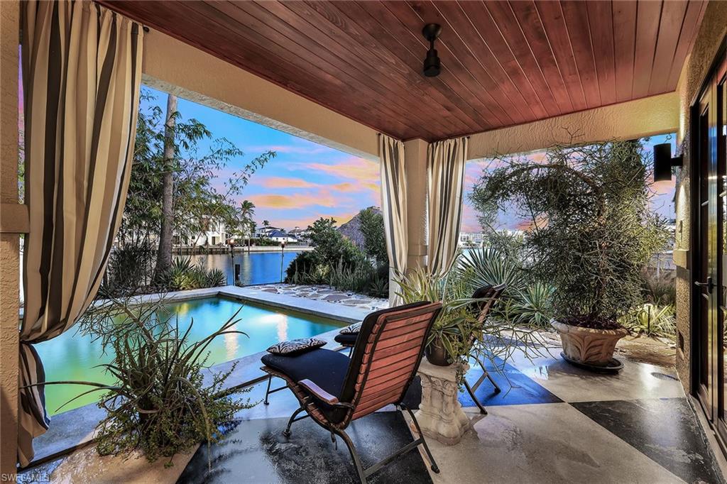 290 Channel Drive Naples, FL 34108 - Photo 44 of 49 a view of a swimming pool with chairs in patio