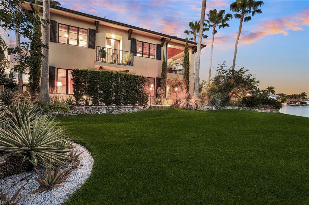 290 Channel Drive Naples, FL 34108 - Photo 9 of 49 a front view of a house with a garden