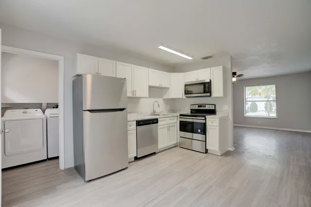a kitchen with a refrigerator stove and wooden cabinets