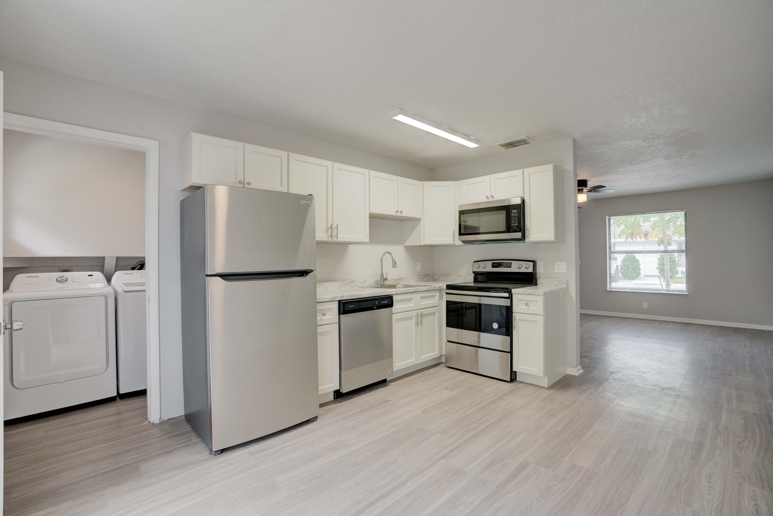 a kitchen with a refrigerator stove and wooden cabinets