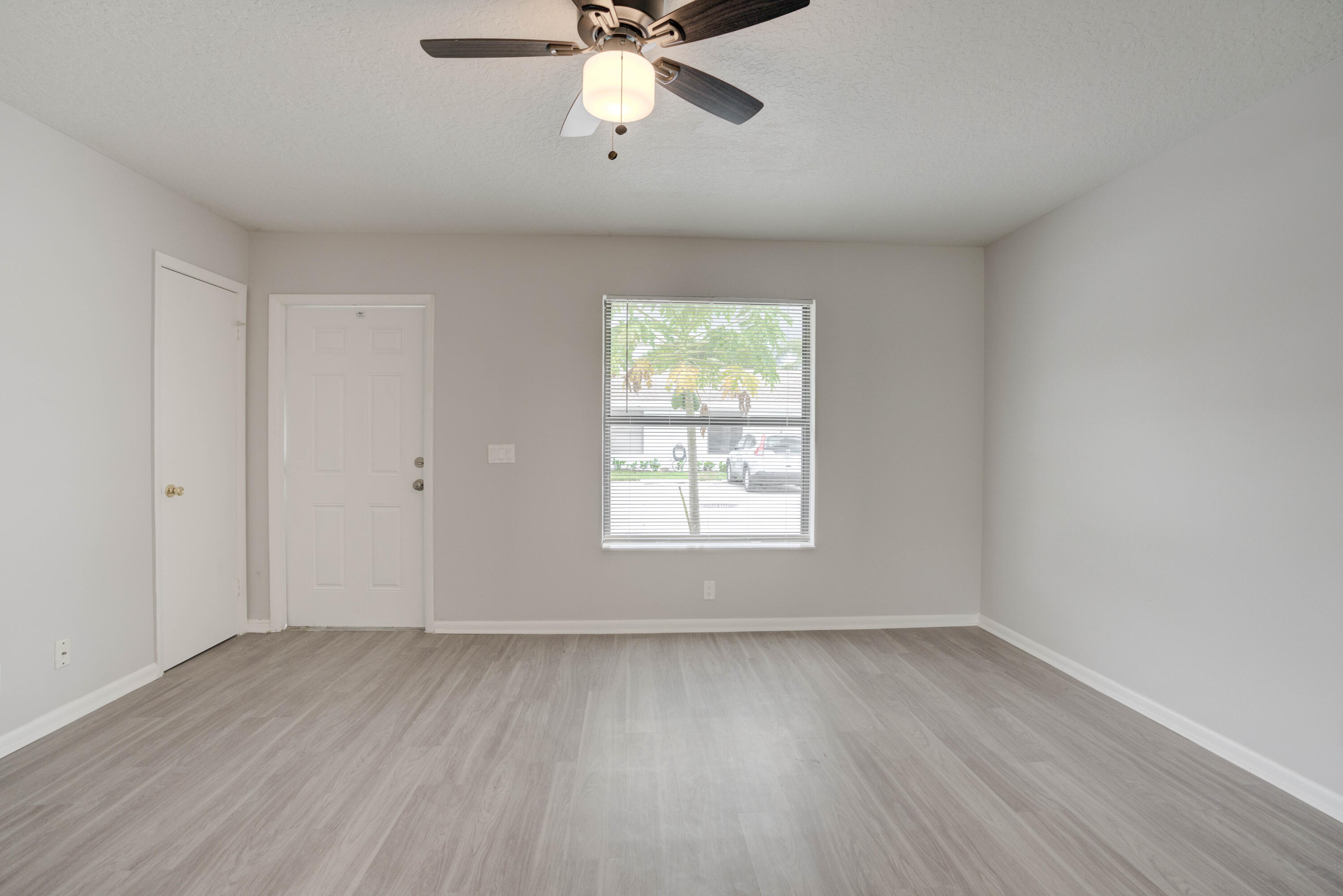 6567 Jupiter Gardens Boulevard, Unit 7 Jupiter, FL 33458 - Photo 11 of 20 wooden floor in an empty room with a window