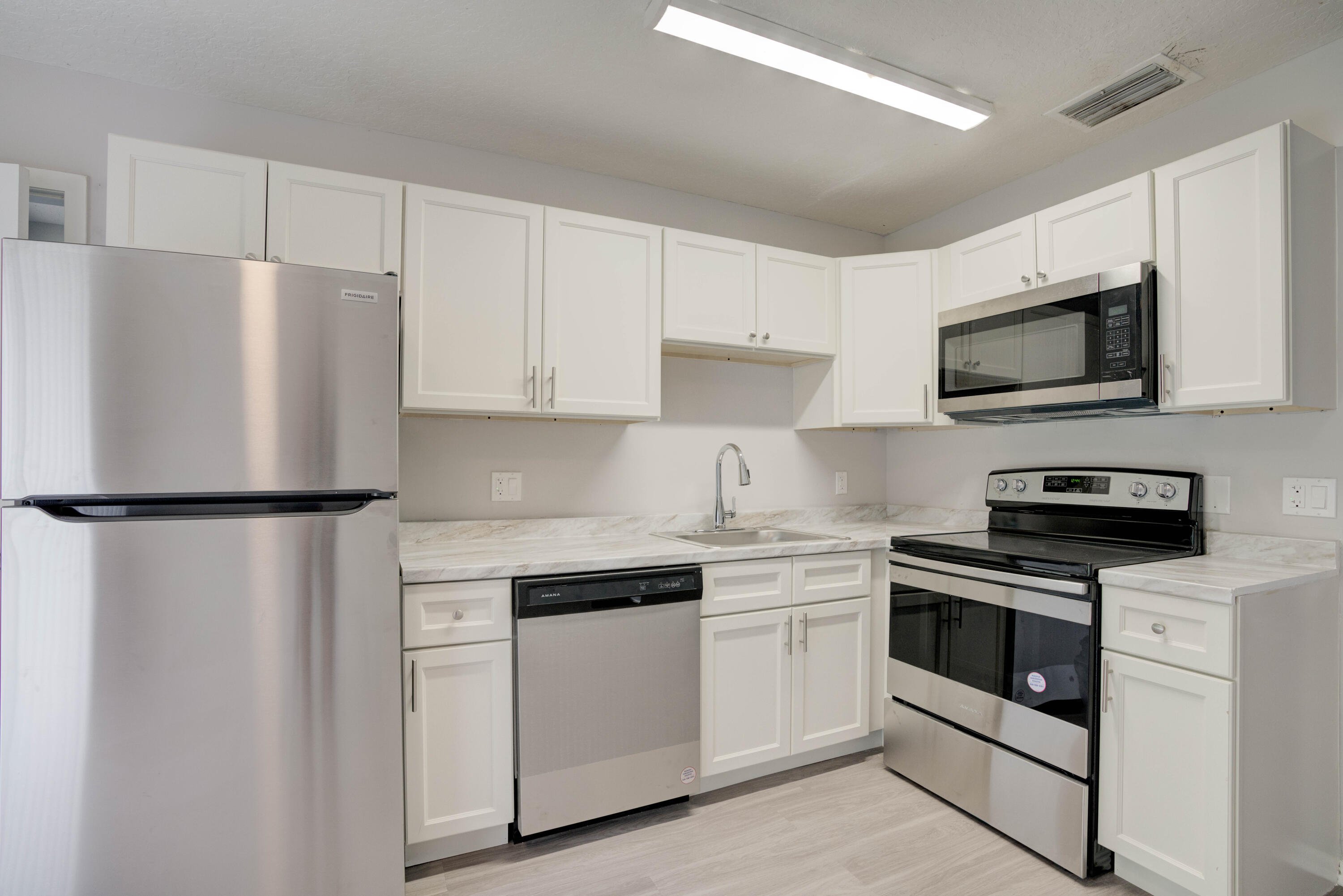6567 Jupiter Gardens Boulevard, Unit 7 Jupiter, FL 33458 - Photo 15 of 20 a kitchen with white cabinets and white appliances