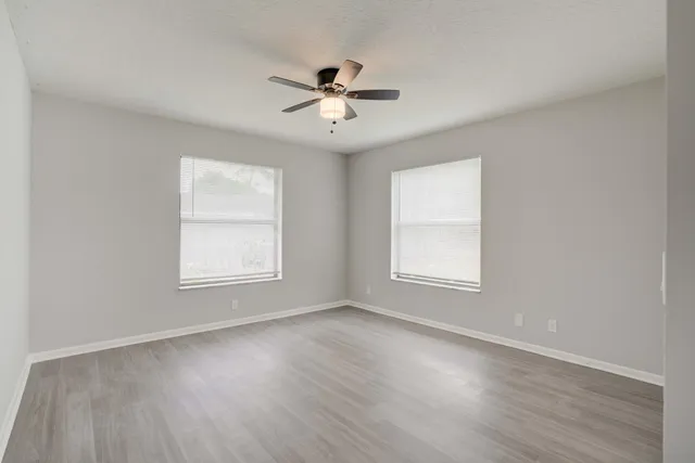 wooden floor in an empty room with a window