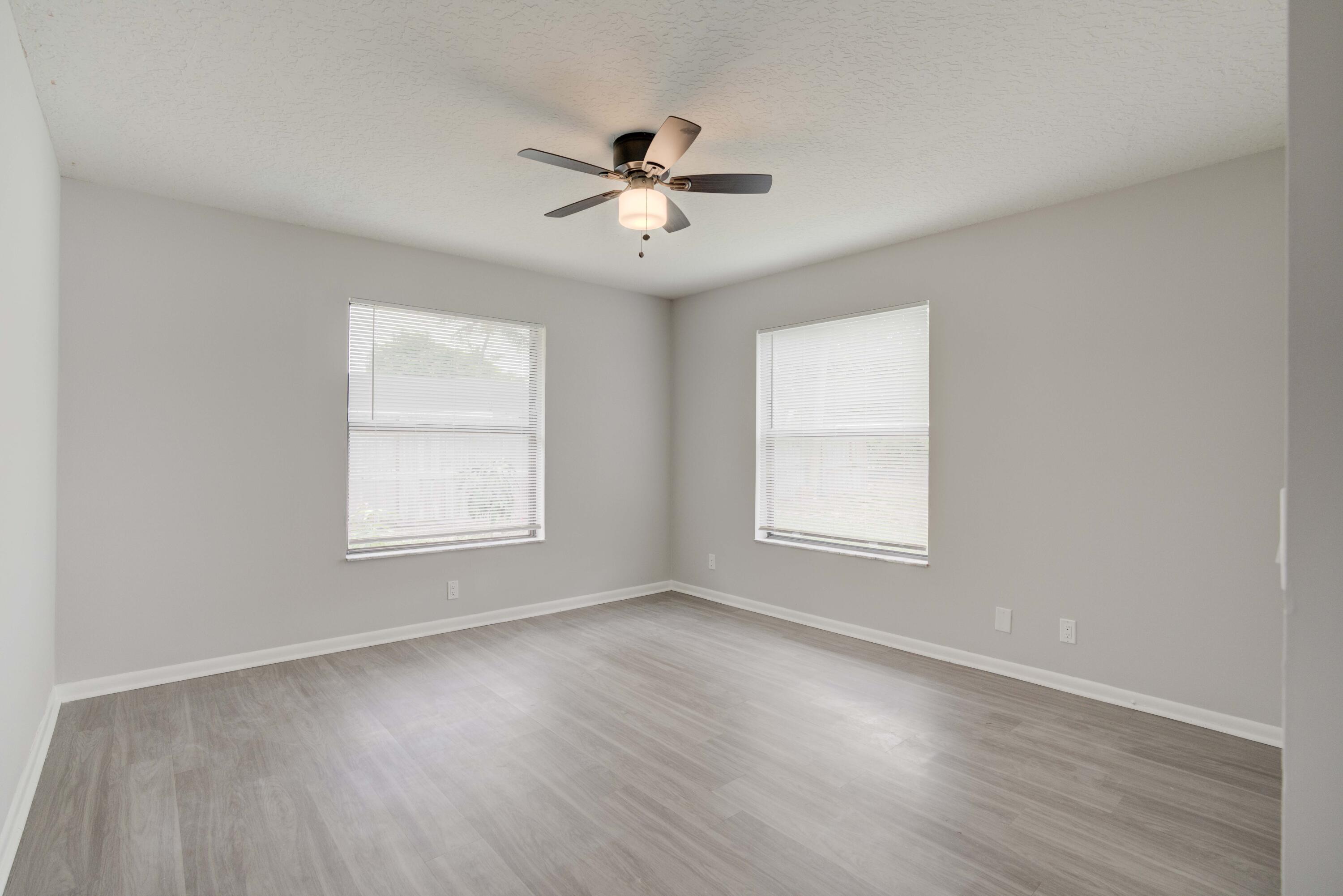 6567 Jupiter Gardens Boulevard, Unit 7 Jupiter, FL 33458 - Photo 17 of 20 wooden floor in an empty room with a window
