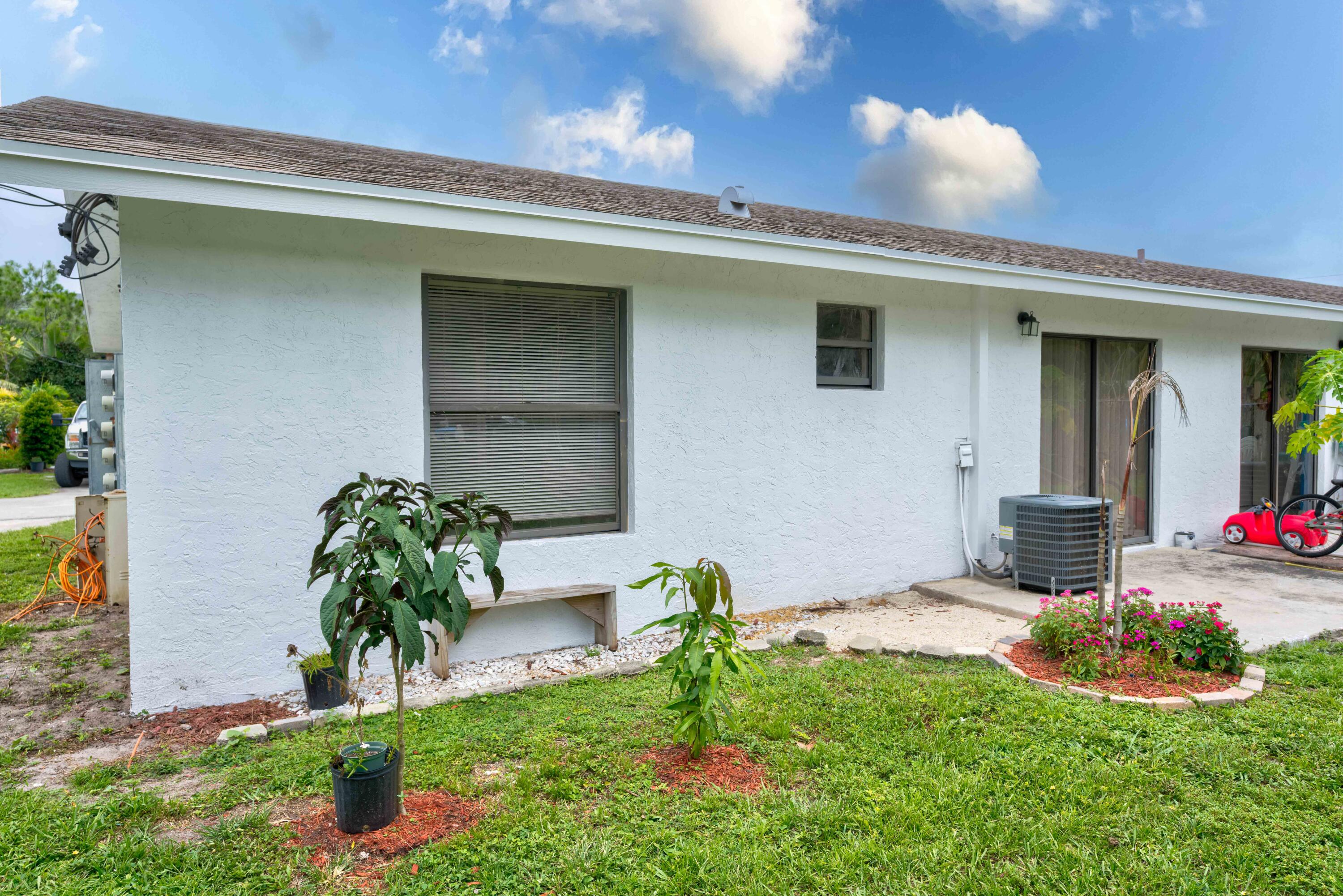 6567 Jupiter Gardens Boulevard, Unit 7 Jupiter, FL 33458 - Photo 20 of 20 a front view of a house with garden