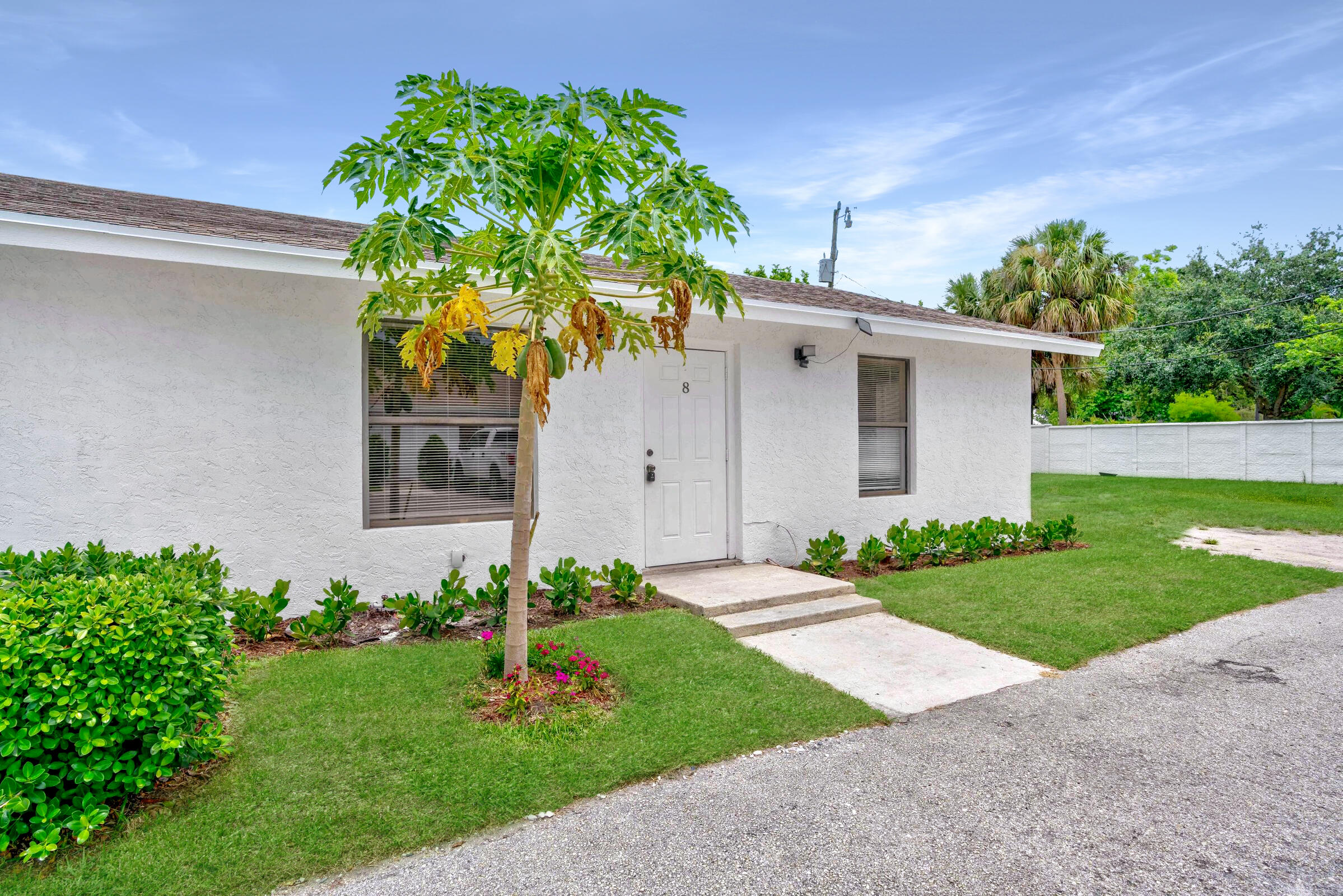 6567 Jupiter Gardens Boulevard, Unit 7 Jupiter, FL 33458 - Photo 2 of 20 a front view of a house with a garden