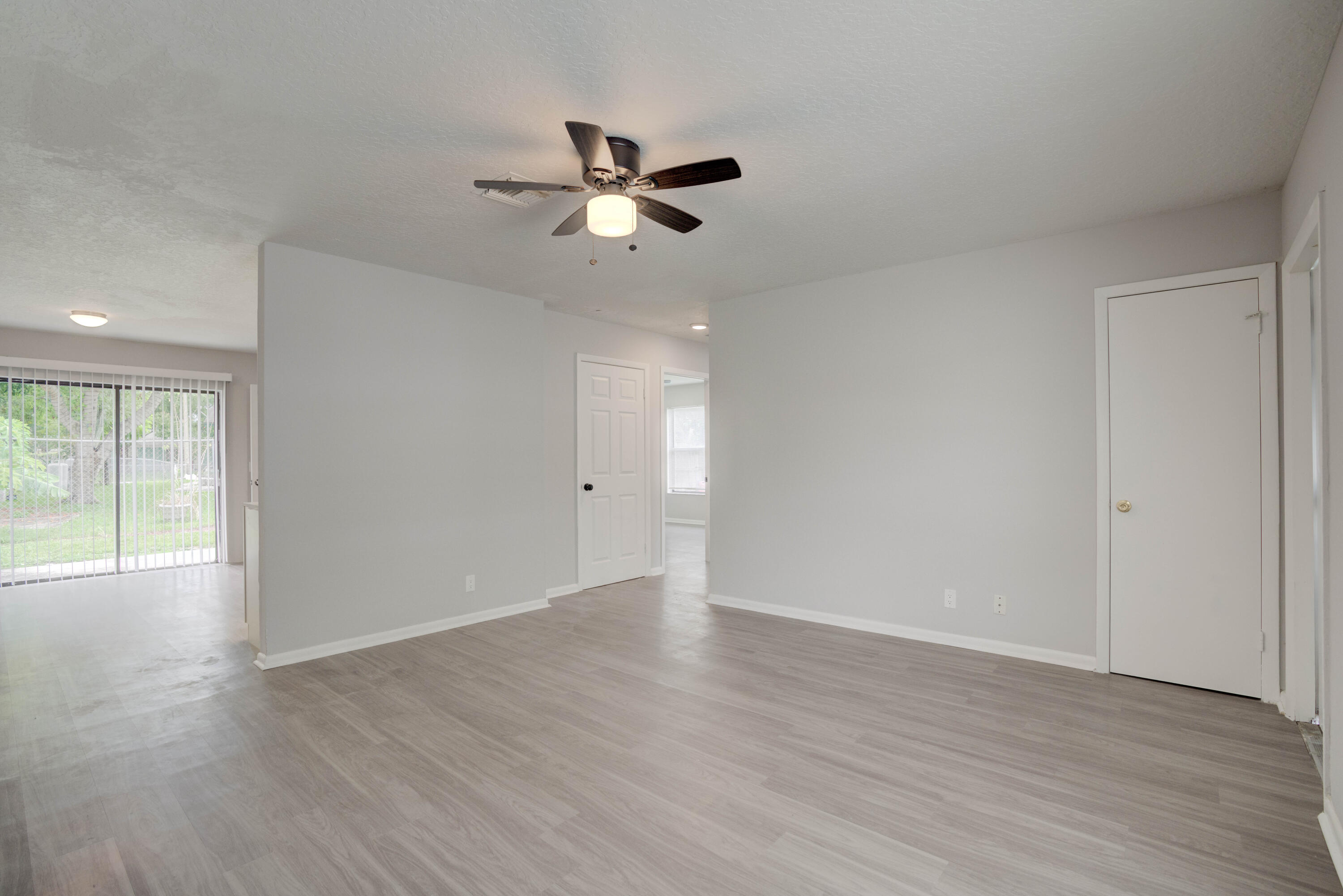 6567 Jupiter Gardens Boulevard, Unit 7 Jupiter, FL 33458 - Photo 9 of 20 a view of an empty room with wooden floor and a window