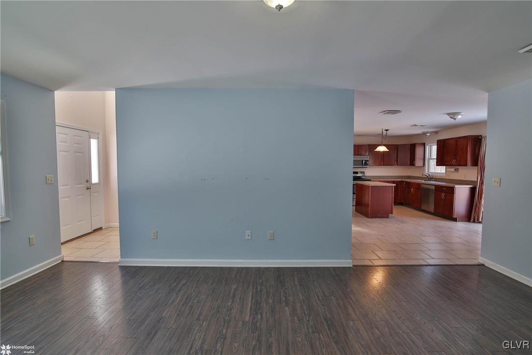 185 Sunset Road East Stroudsburg, PA 18302 - Photo 12 of 49 an empty room with wooden floor and kitchen view