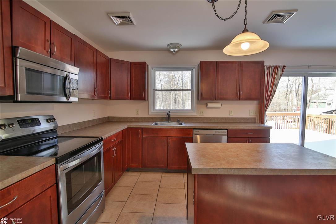 185 Sunset Road East Stroudsburg, PA 18302 - Photo 15 of 49 a kitchen with granite countertop a stove cabinets and window