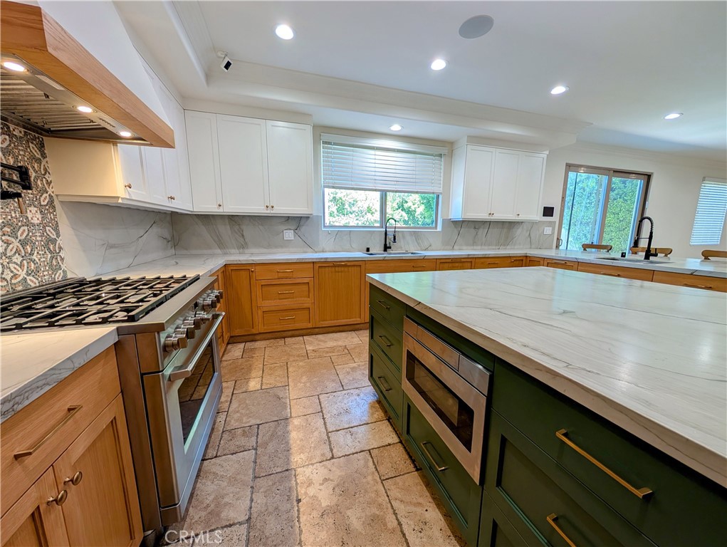 16659 Addison Street Encino, CA 91436 - Photo 15 of 48 a kitchen with stainless steel appliances granite countertop a sink and cabinets