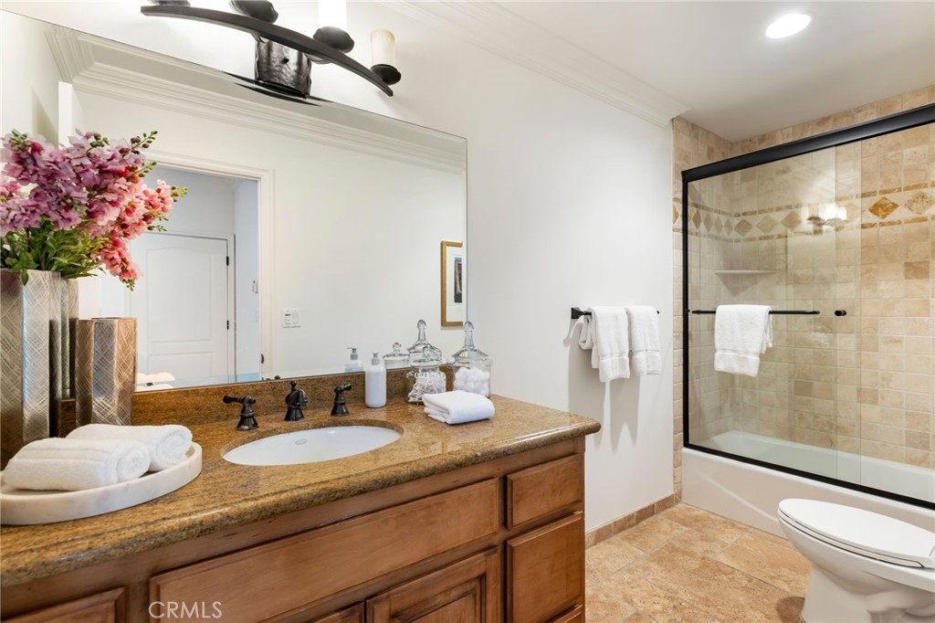 16659 Addison Street Encino, CA 91436 - Photo 23 of 48 a bathroom with a granite countertop sink a mirror and a shower