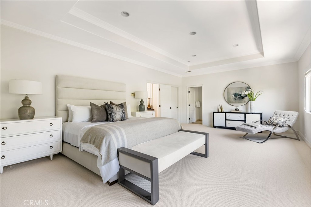 16659 Addison Street Encino, CA 91436 - Photo 32 of 48 a spacious bedroom with a bed and a chandelier