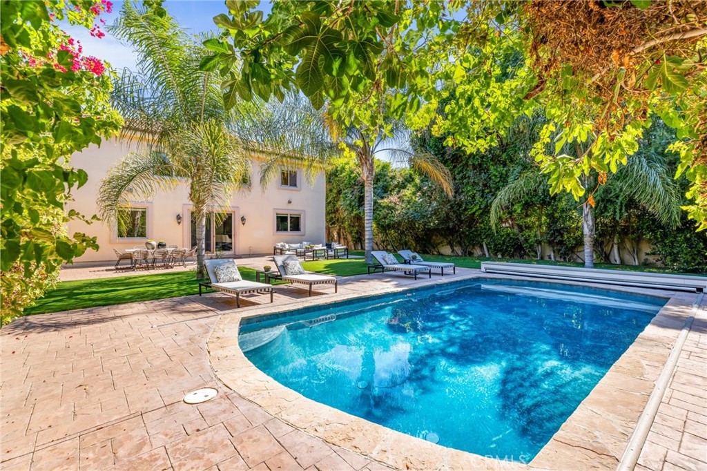 16659 Addison Street Encino, CA 91436 - Photo 43 of 48 a view of a swimming pool with potted plants and large trees