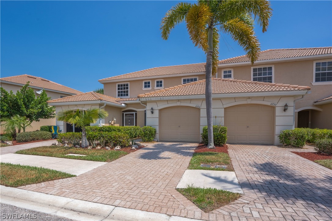 11731 Eros Road Lehigh Acres, FL 33971 - Photo 2 of 33 a front view of a house with a yard and potted plants