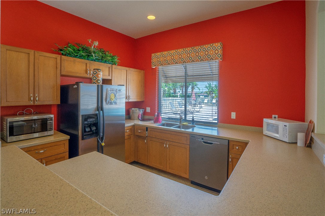 11731 Eros Road Lehigh Acres, FL 33971 - Photo 30 of 33 a kitchen with stainless steel appliances a refrigerator and a stove