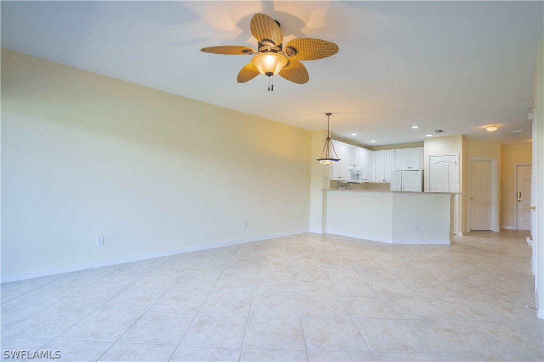 11731 Eros Road Lehigh Acres, FL 33971 - Photo 10 of 33 a view of kitchen with a refrigerator cabinets and a ceiling fan