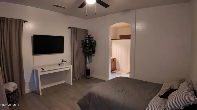 a room with a bed and a chandelier fan