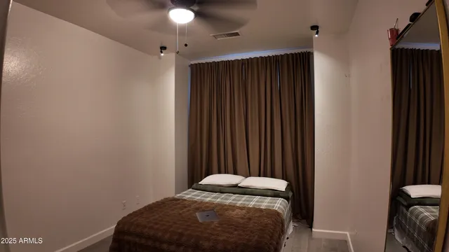 a view of an empty room with wooden floor and windows