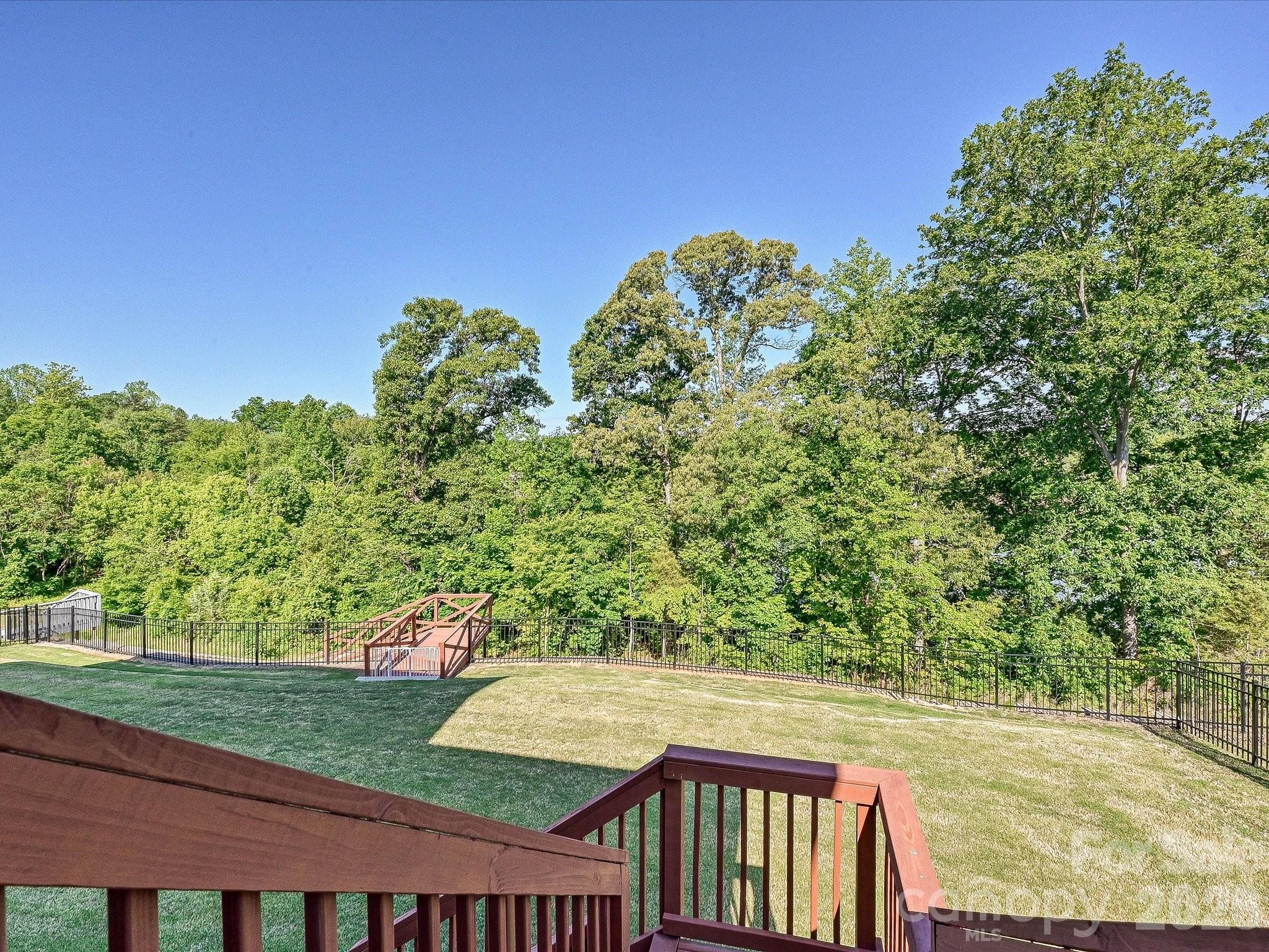 315 West Waterlynn Road Mooresville, NC 28117 - Photo 21 of 46 a view of a yard with plants and a wooden fence