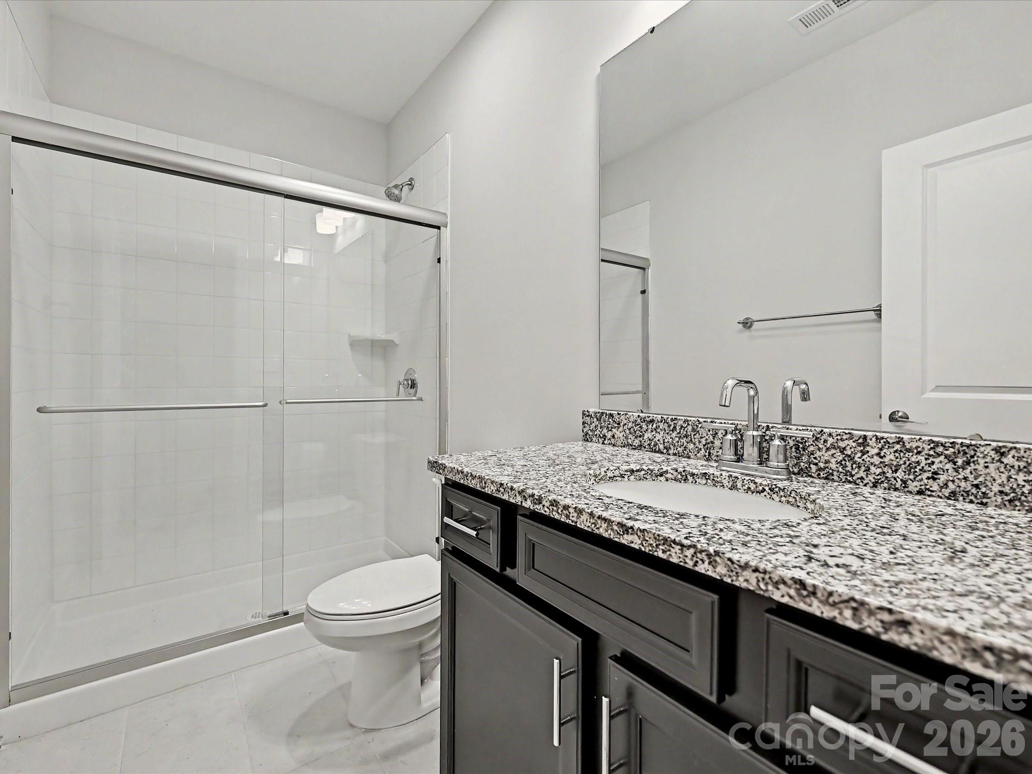 315 West Waterlynn Road Mooresville, NC 28117 - Photo 43 of 46 a bathroom with a granite countertop sink a toilet a mirror and shower