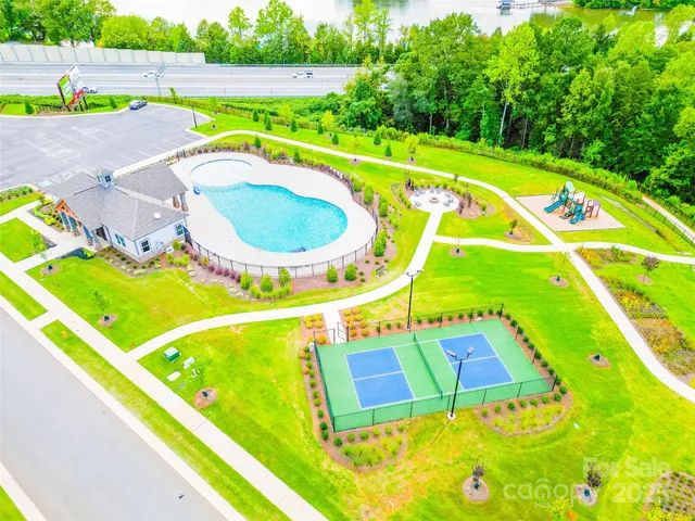 a view of a swimming pool with a chairs and table in the patio