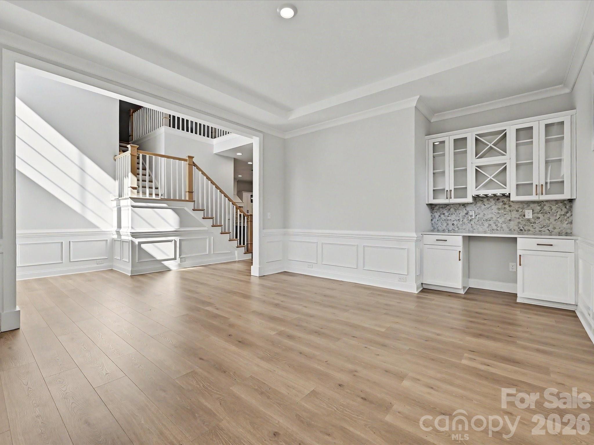 315 West Waterlynn Road Mooresville, NC 28117 - Photo 9 of 46 a view of an empty room with wooden floor and a kitchen