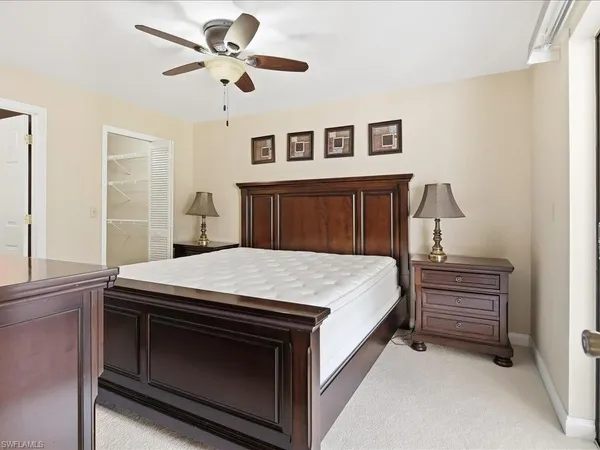 a bedroom with a large bed a chandelier and dresser