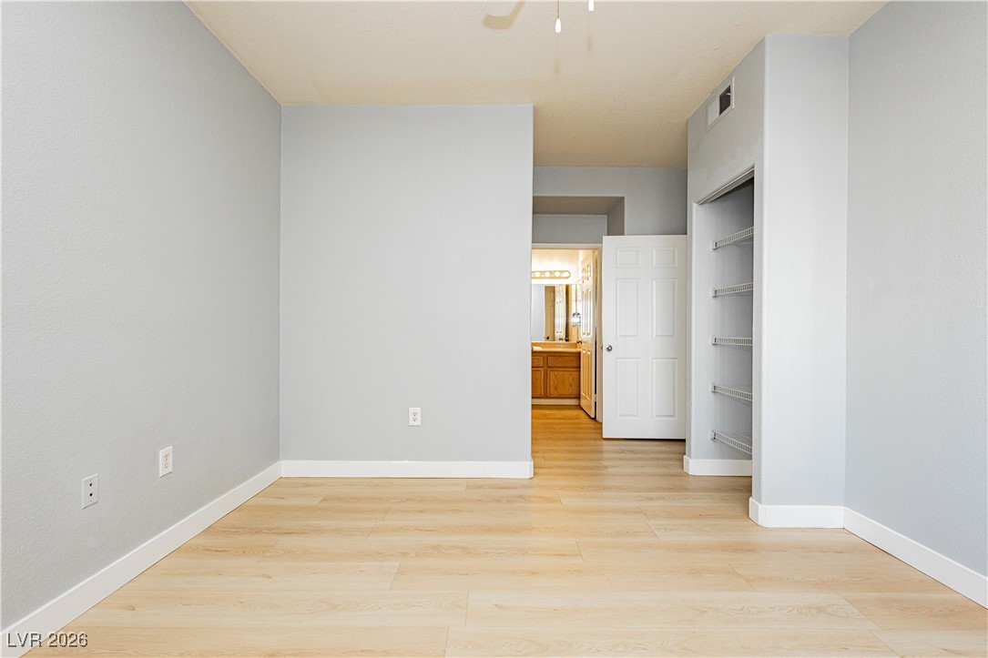 3318 North Decatur Boulevard, Unit 1082 Las Vegas, NV 89130 - Photo 20 of 25 Unfurnished bedroom with light wood-style flooring, ceiling fan, and connected bathroom