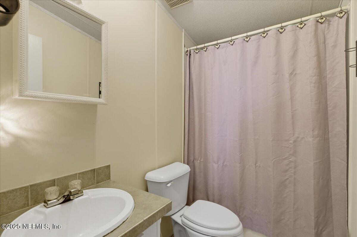 107 Indiana Street Crescent City, FL 32112 - Photo 12 of 19 a bathroom with a sink a toilet and shower curtain