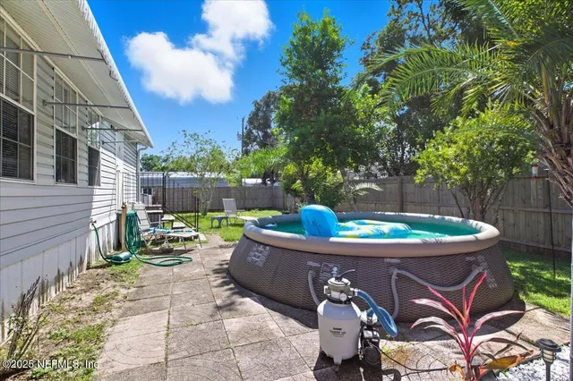 a view of a patio with table and chairs potted plants with wooden fence